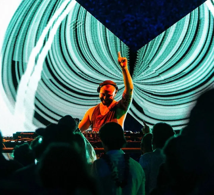 Murray con el brazo en alto bajo una pantalla de luces verdes en Full Moon Nicaragua